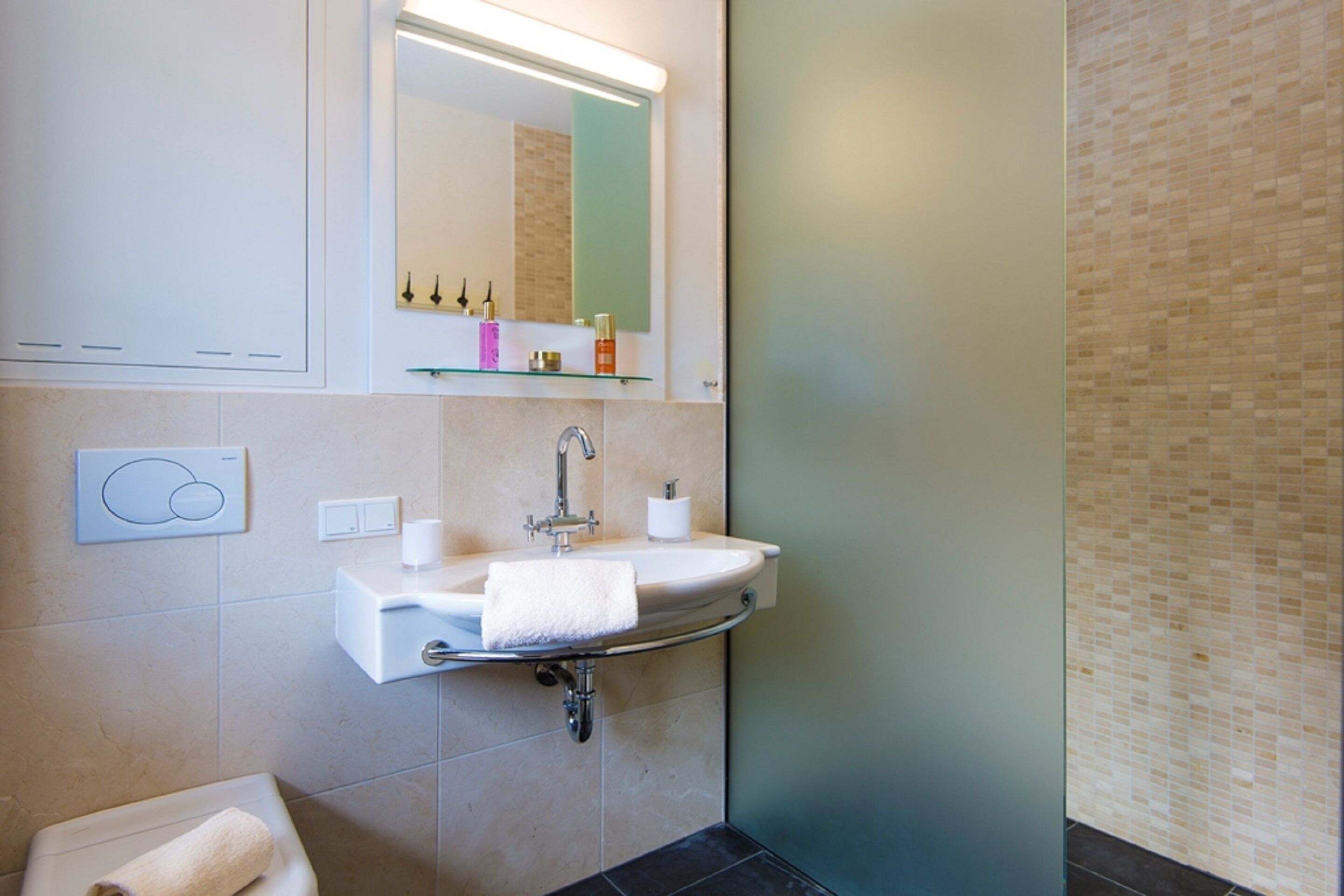 A bathroom with a sink, mirror, and towel.