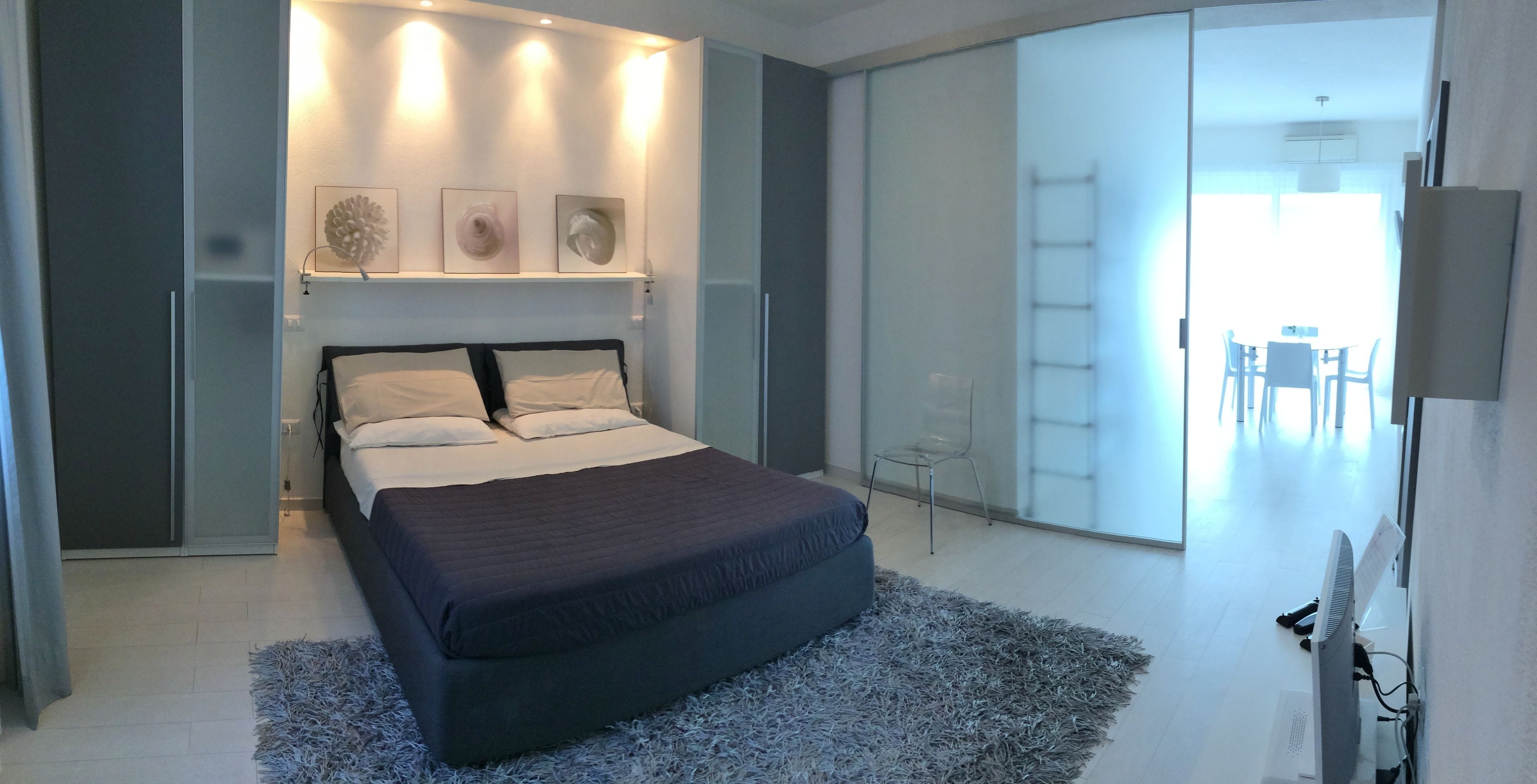 Ein modernes Schlafzimmer mit Bett, Nachttischen, Schreibtisch und Stuhl.