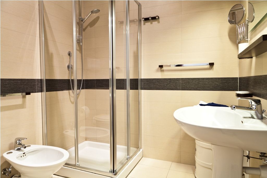 Une salle de bain moderne avec une douche à parois de verre, un lavabo et des toilettes.