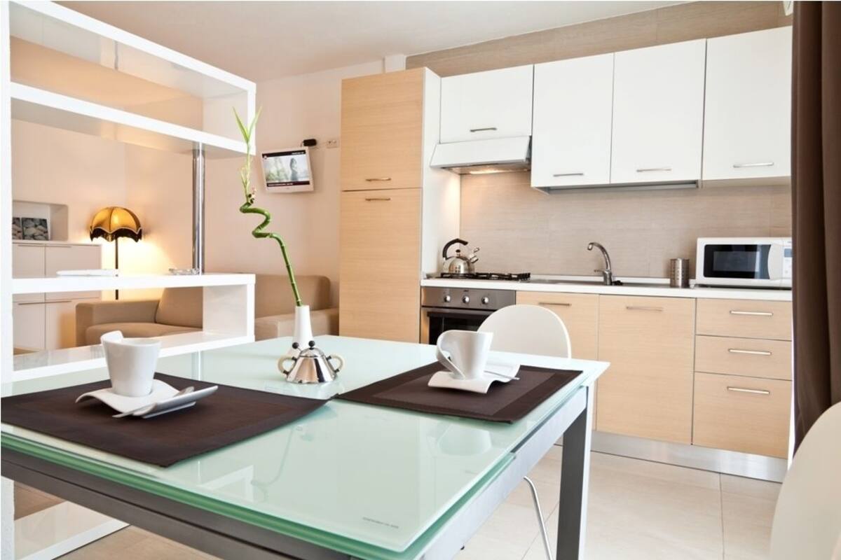 A modern kitchen with white cabinets, a microwave, and a gas stove.