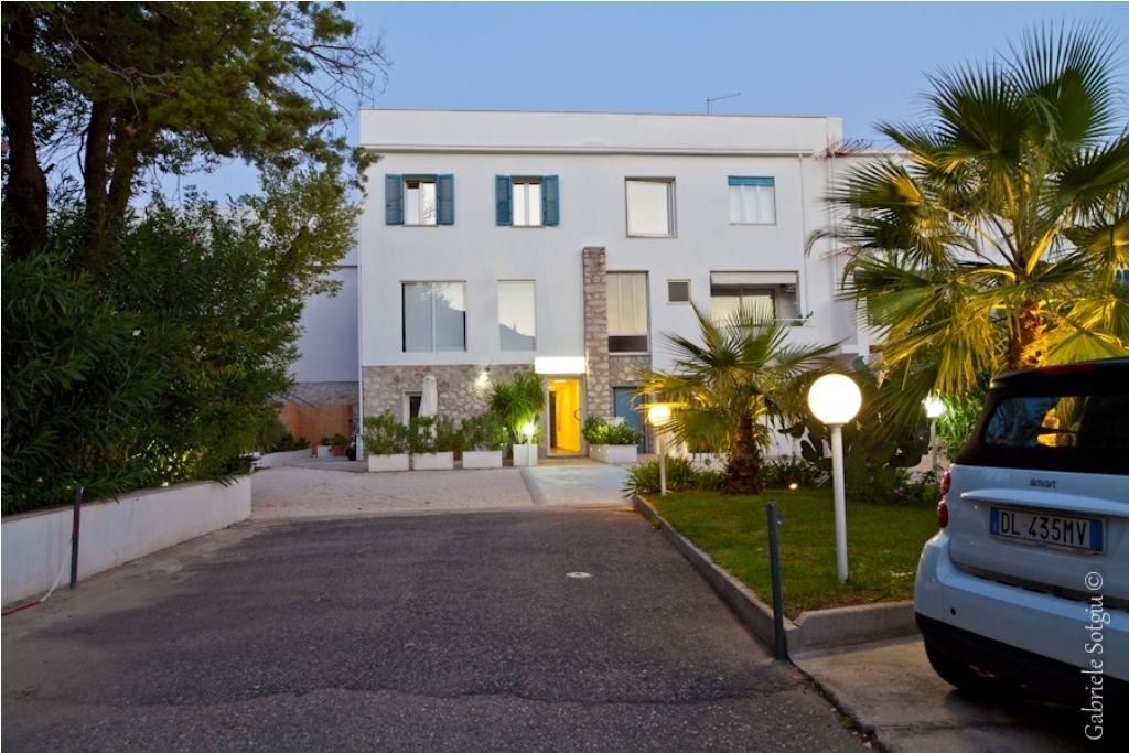 Un edificio moderno de dos pisos con techo plano, fachada de piedra y una puerta amarilla.