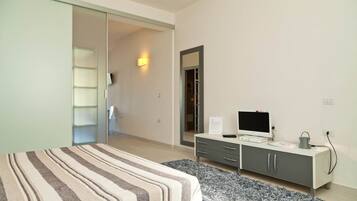 Une chambre moderne avec un lit, une télévision et un bureau doté de tiroirs.