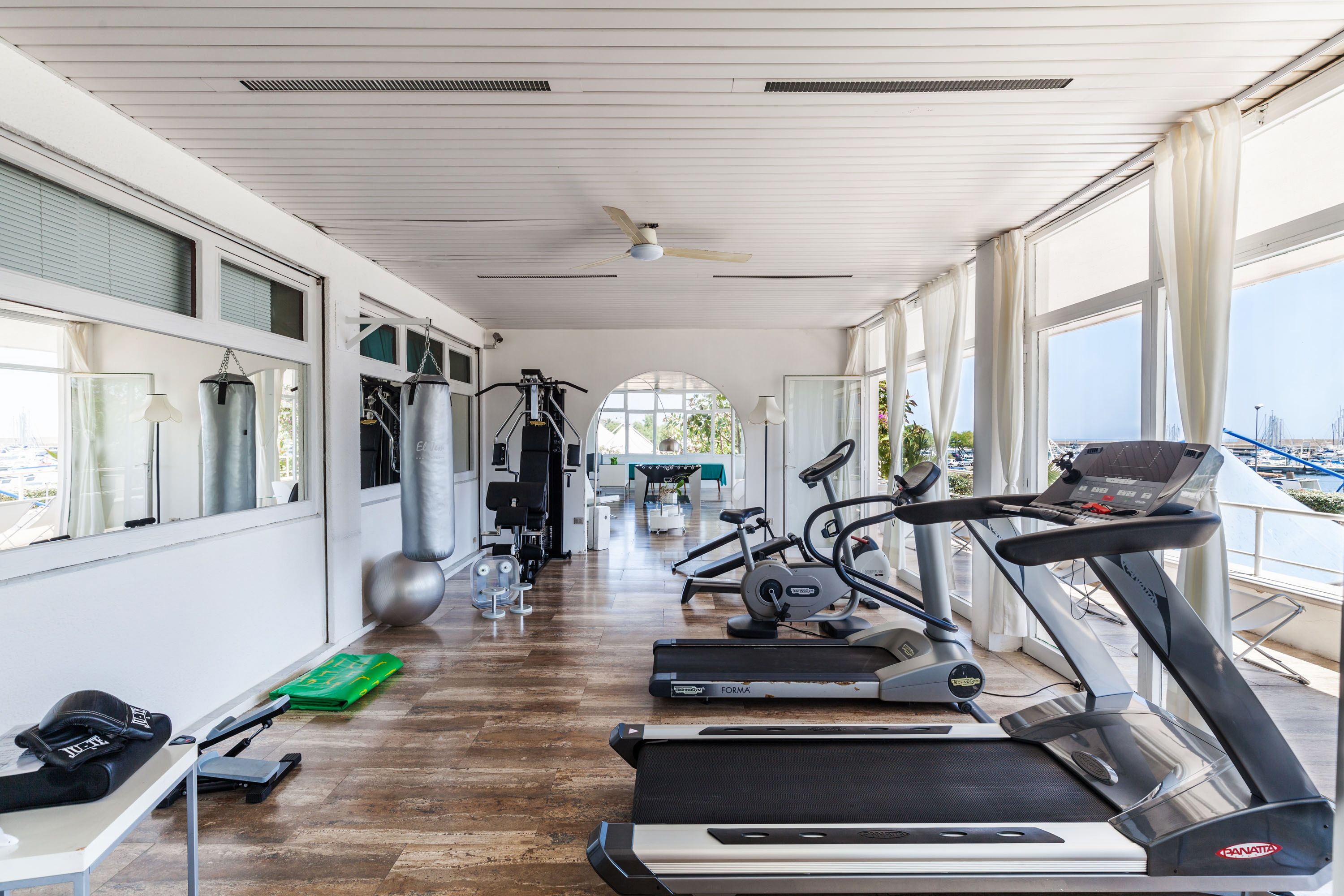 A gym with treadmills, weights, and exercise equipment.