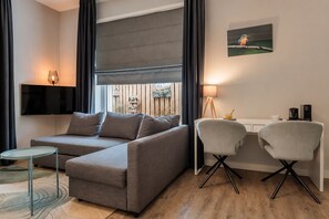  Comfort Plus Room | Living area | 32-inch TV with cable channels, foosball, table tennis - Paviljoen Hotel (Rhenen)