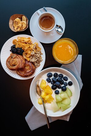 Enjoy a delicious breakfast spread with a variety of options, including pastries, yogurt, cereal, and fresh fruit.