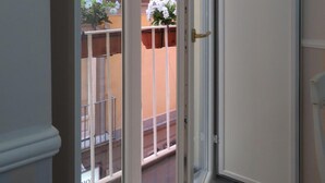 A view from inside a room to a balcony with a railing, a door, and a window. - Olimpo degli Dei (Naples)