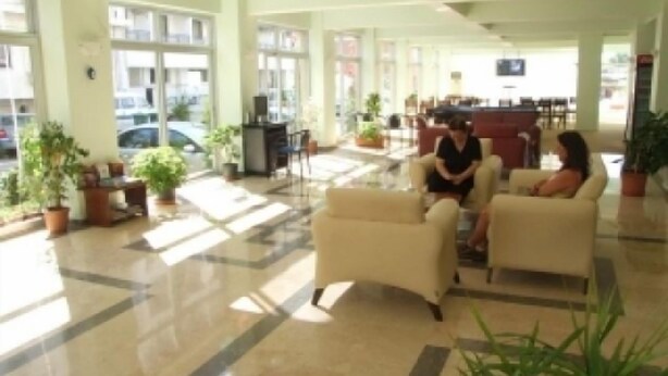 A spacious lobby with a reception desk, seating area, and potted plants. - Çesme Sirin Villa Otel (Cesme)