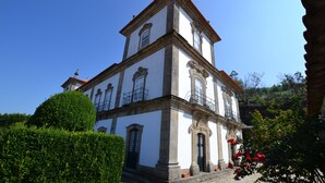 Un edificio histórico con fachada simétrica, numerosas ventanas y una entrada central.