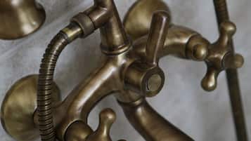 A brass faucet with multiple handles and a flexible hose.