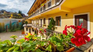 A yellow building with balconies and a garden in the foreground. - Long Street Hotel (Brasov)