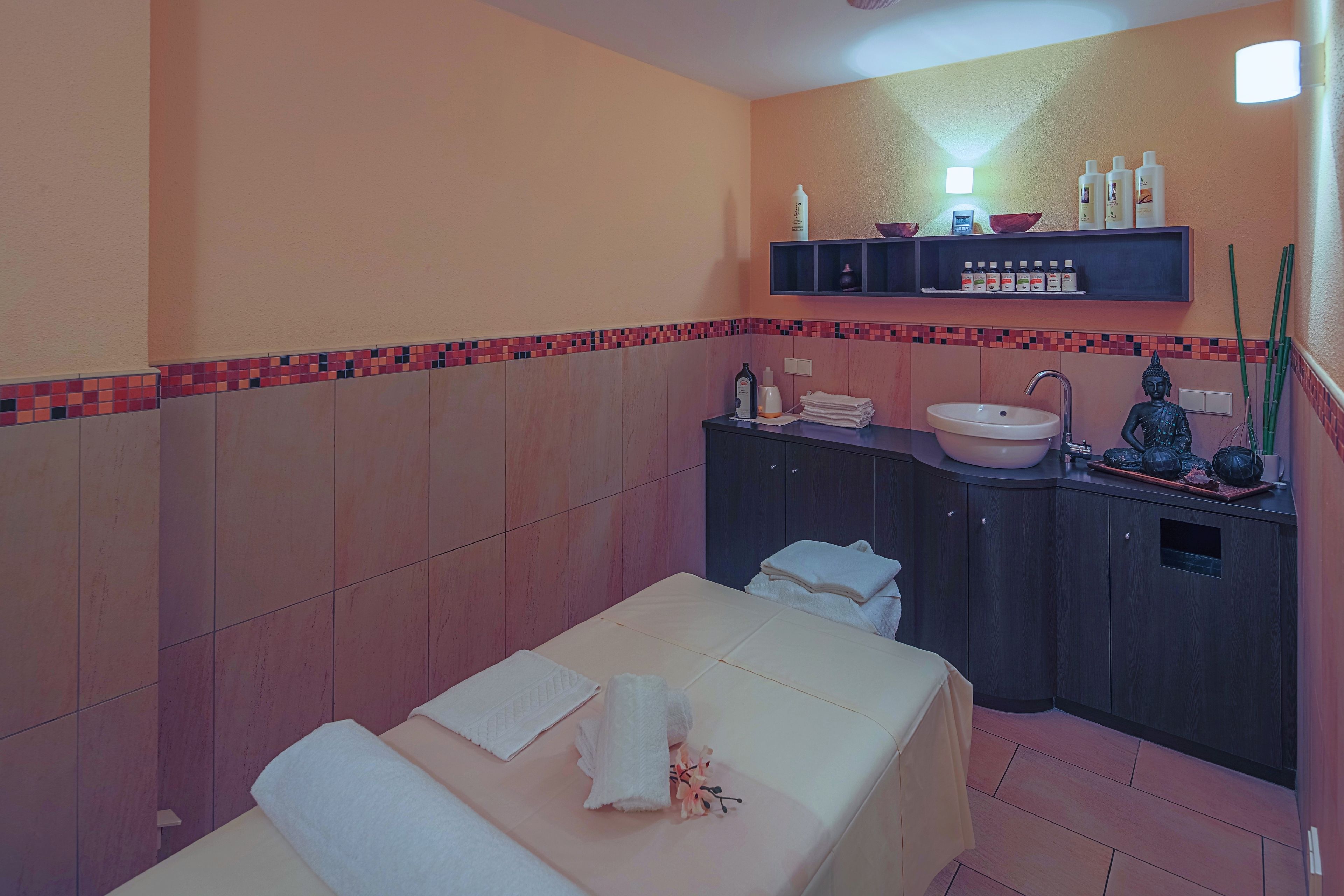 A hotel room with a bed, a sink, and a vanity with toiletries.