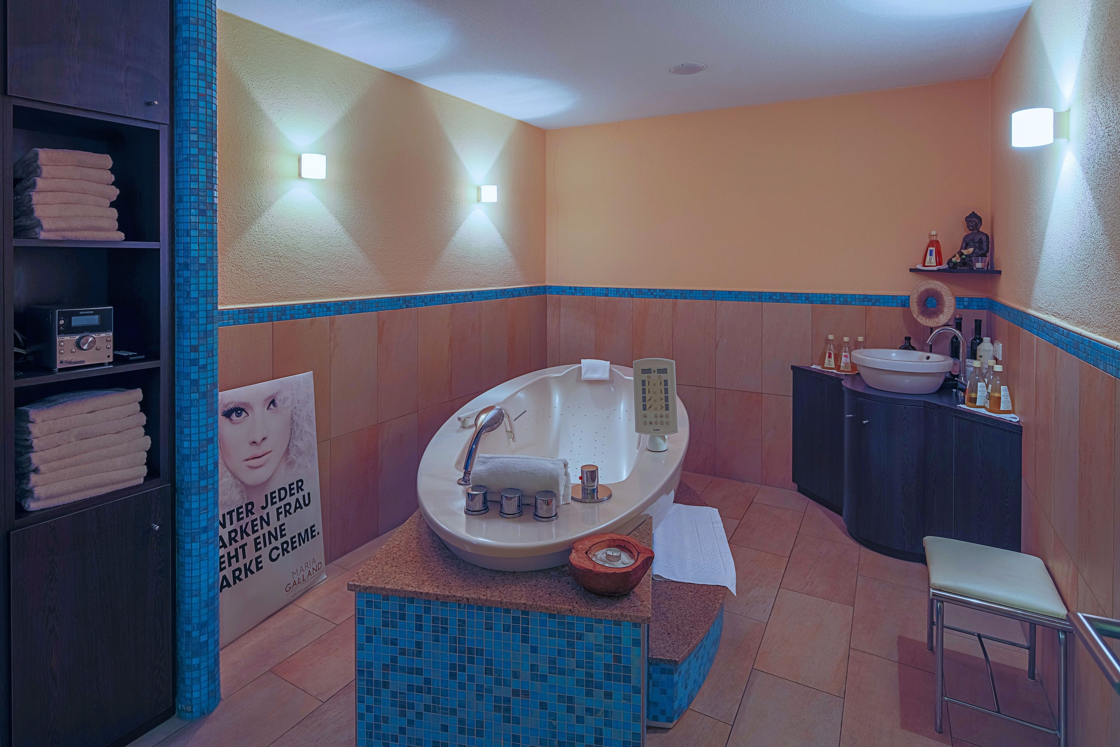 Une salle de bain moderne avec une baignoire sur pieds, un meuble-lavabo et un petit tabouret.