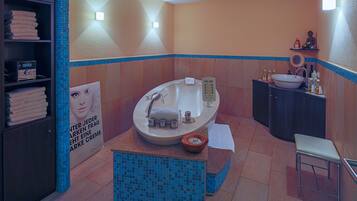 Une salle de bain moderne avec une baignoire sur pieds, un meuble-lavabo et un petit tabouret.