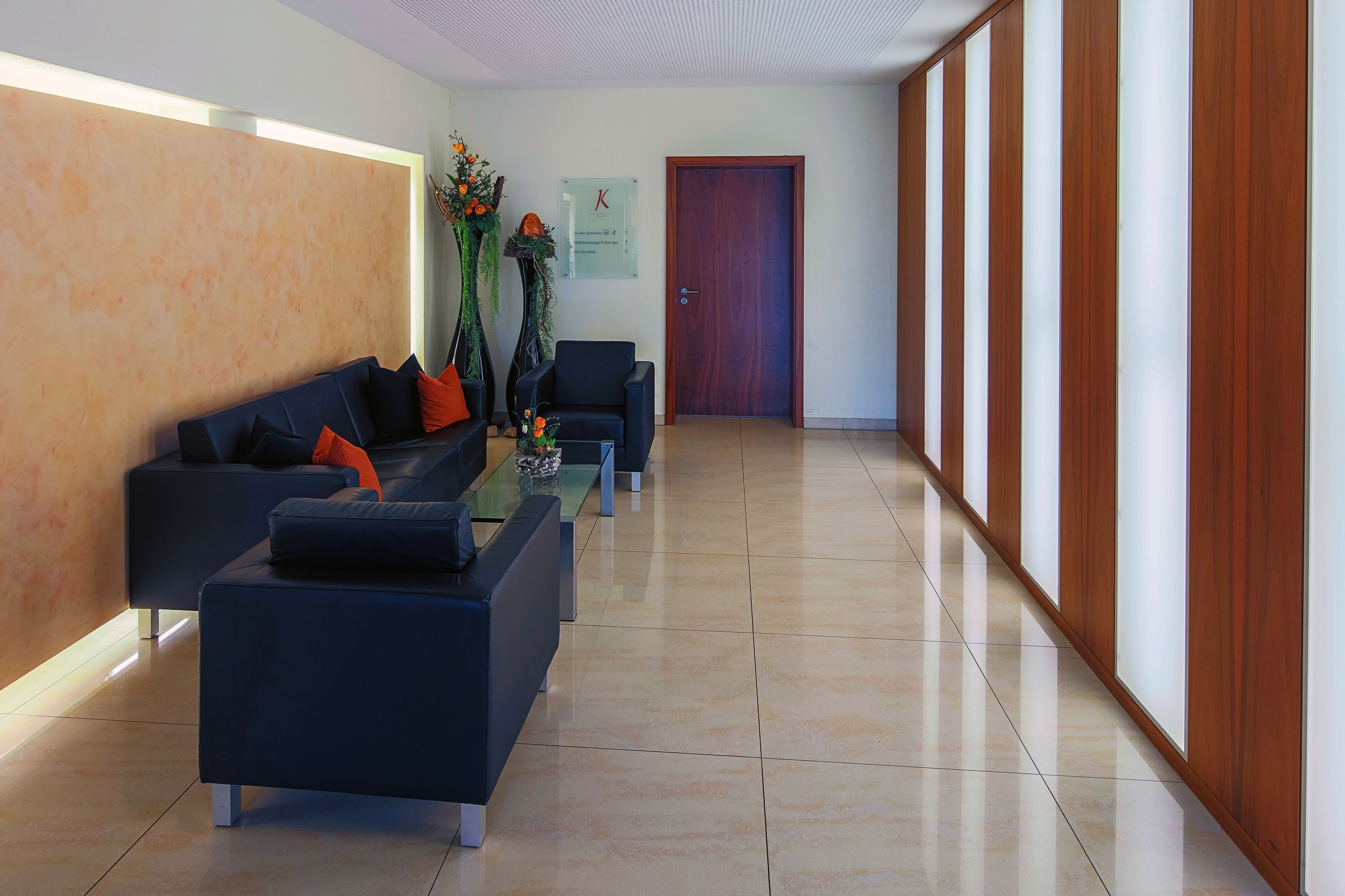 Un área de recepción con un sofá, sillones y una mesita de centro.