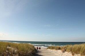 A coastal pathway leading to the beach with dunes and ocean views.