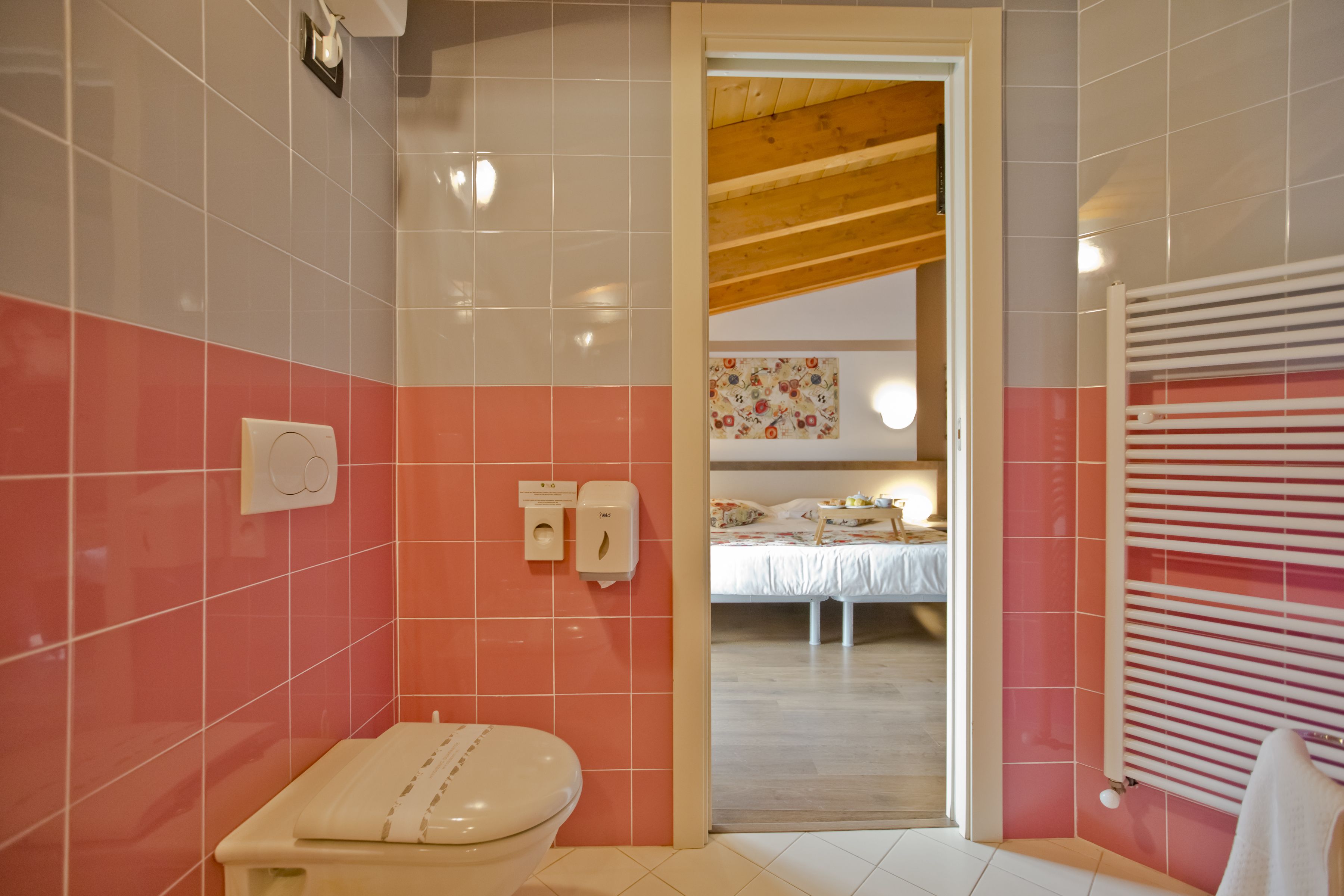Une salle de bain équipée de toilettes, d’un sèche-mains et d’un porte-serviettes.