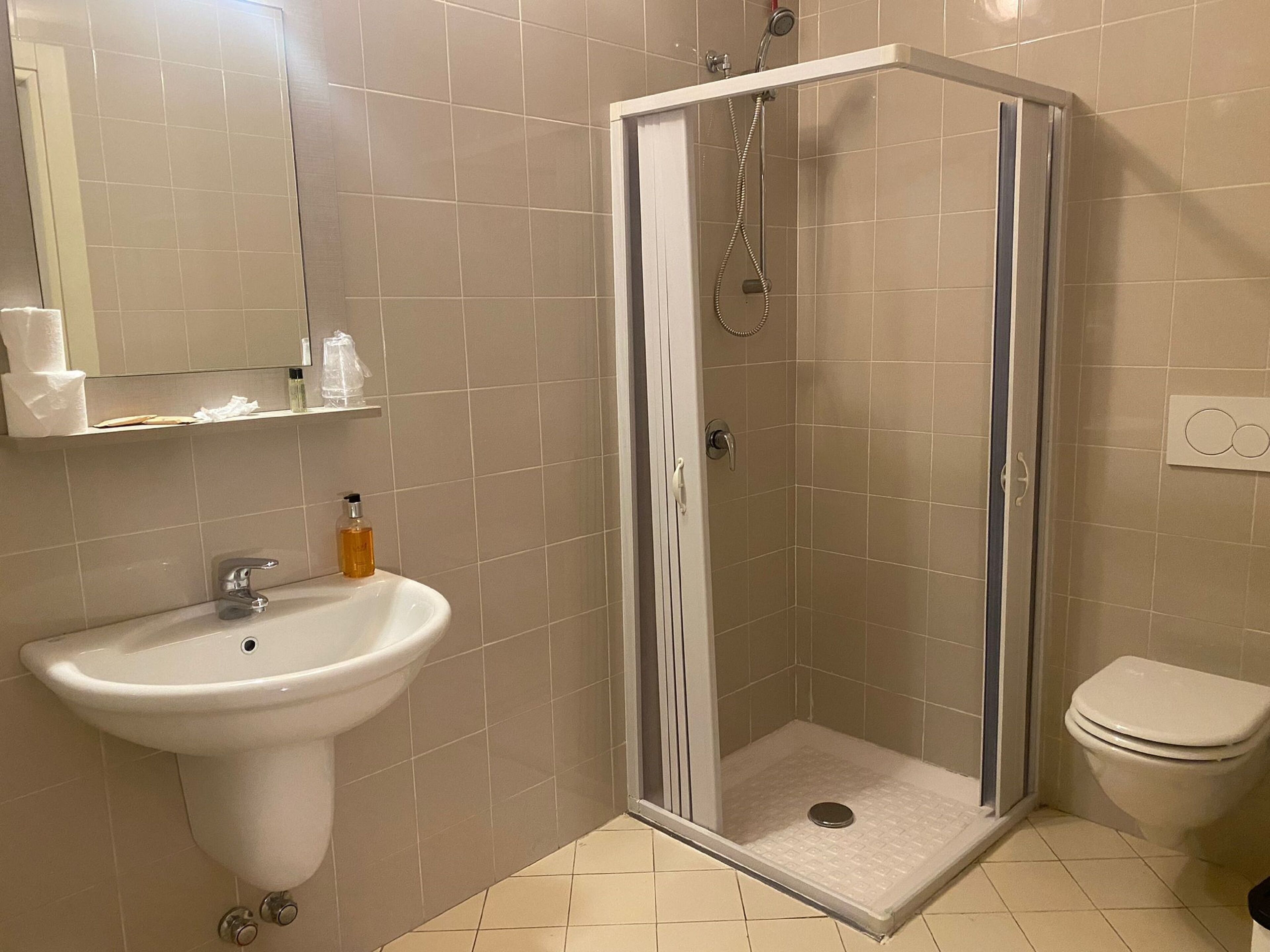 A bathroom with a shower, sink, and toilet.