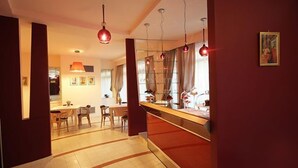 A hotel lobby with a dining area, a reception desk, and a large window with curtains. - Palace Hotel Una Nuova Strada (Nocera Terinese)