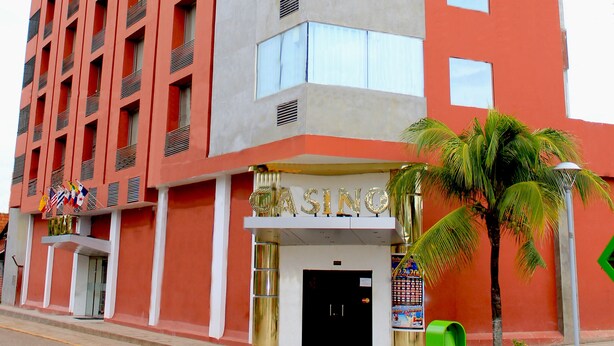 A multi-story hotel with a red and grey facade, a visible entrance, and a sign indicating it is a casino.