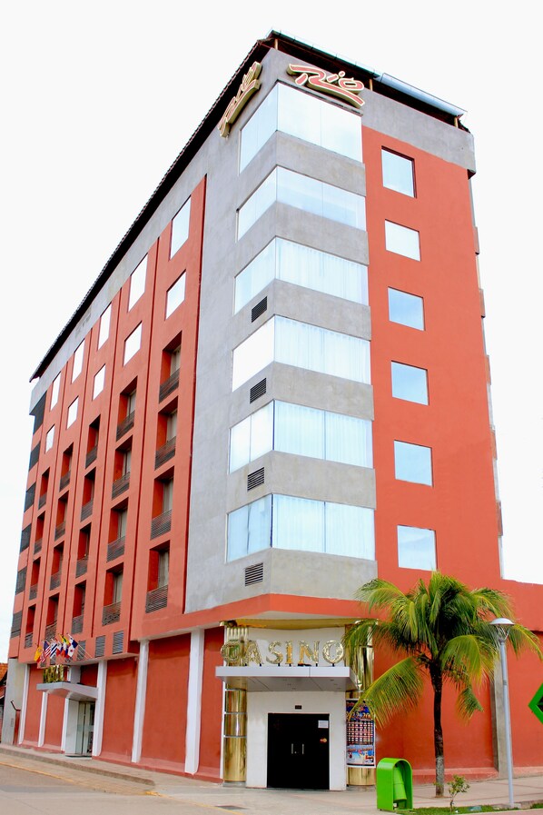 A multi-story hotel with a red and grey facade, a visible entrance, and a sign indicating it is a casino.
