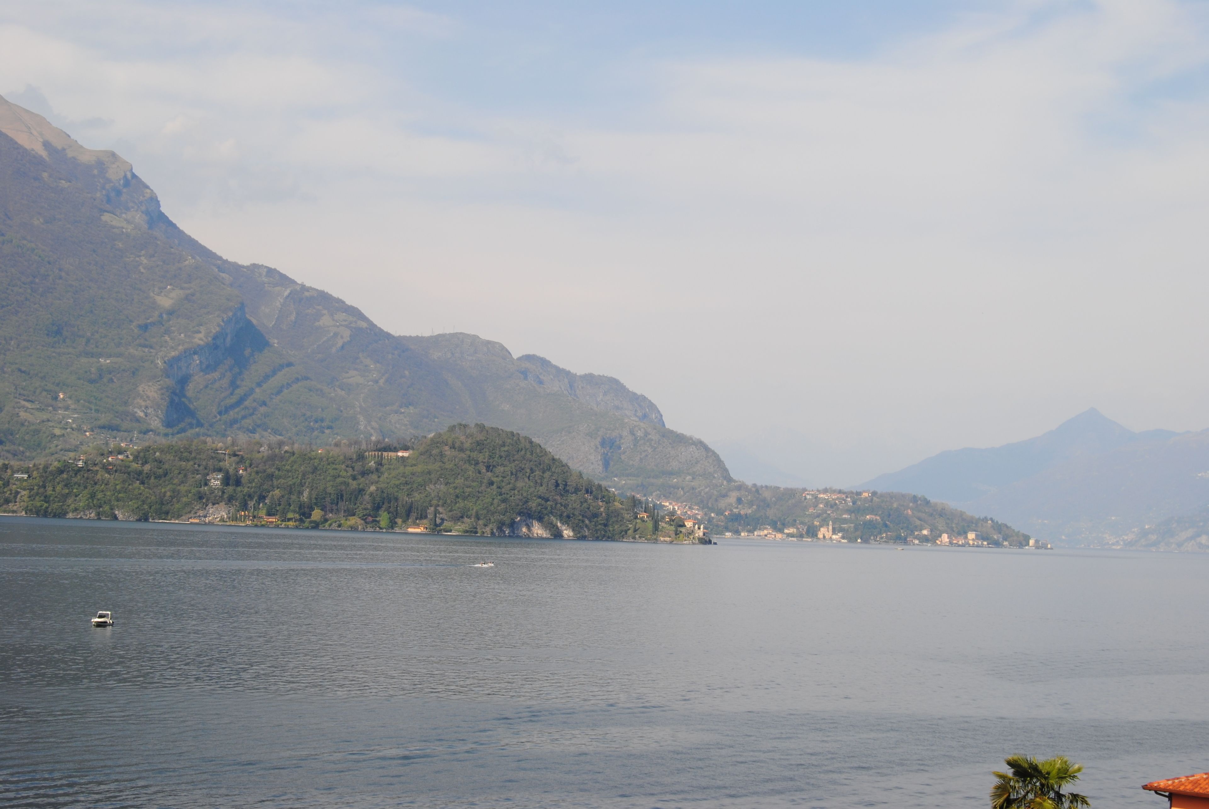 A lake with mountains in the background and a small boat in the water.