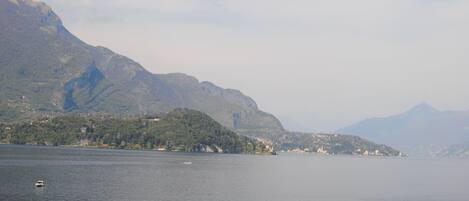 A lake with mountains in the background and a small boat in the water.