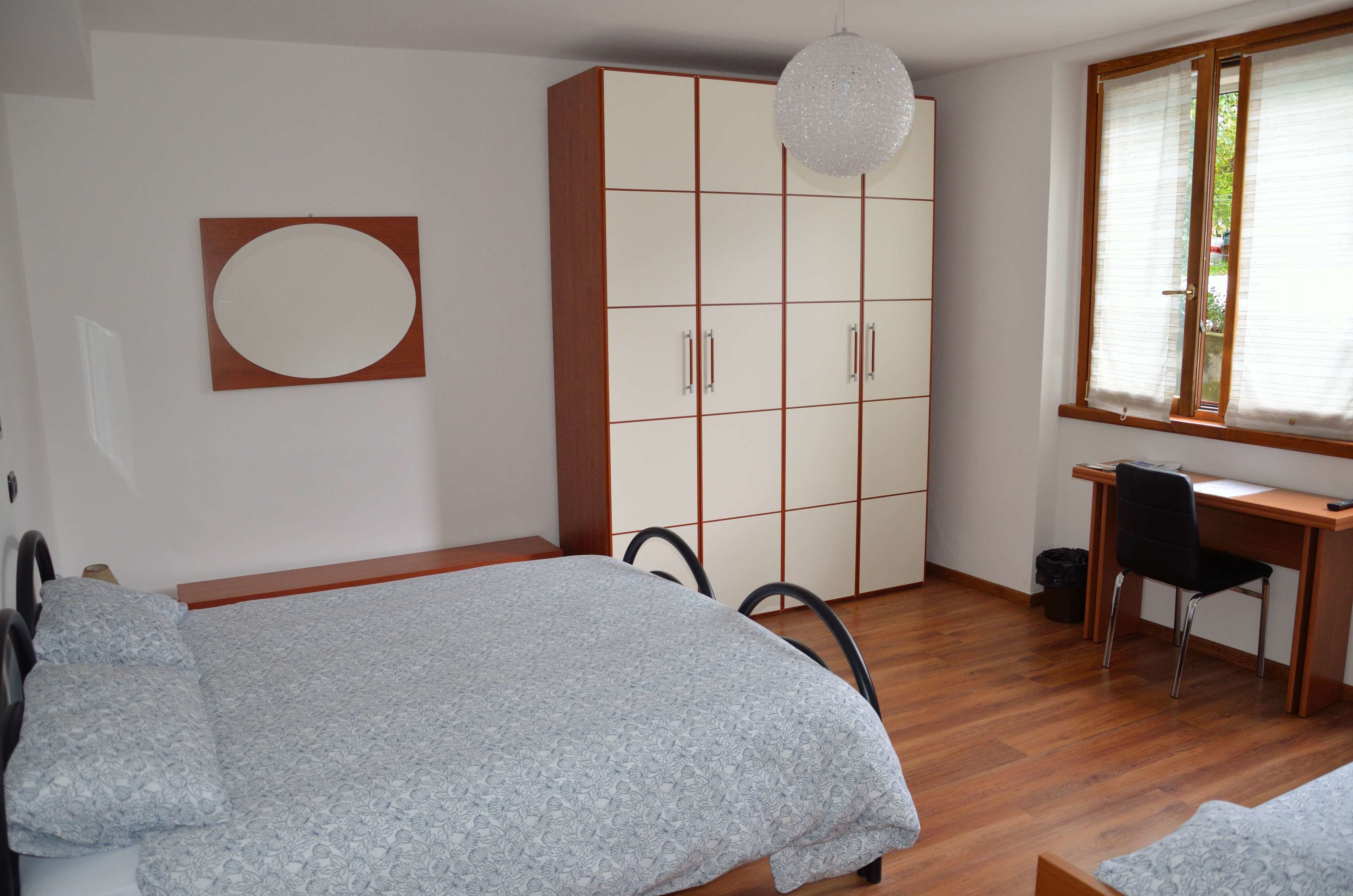 Una camera da letto con un letto, un armadio, una scrivania e una sedia.