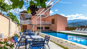 A poolside area with outdoor seating and a view of a building with a sign reading "GLOTERIA".