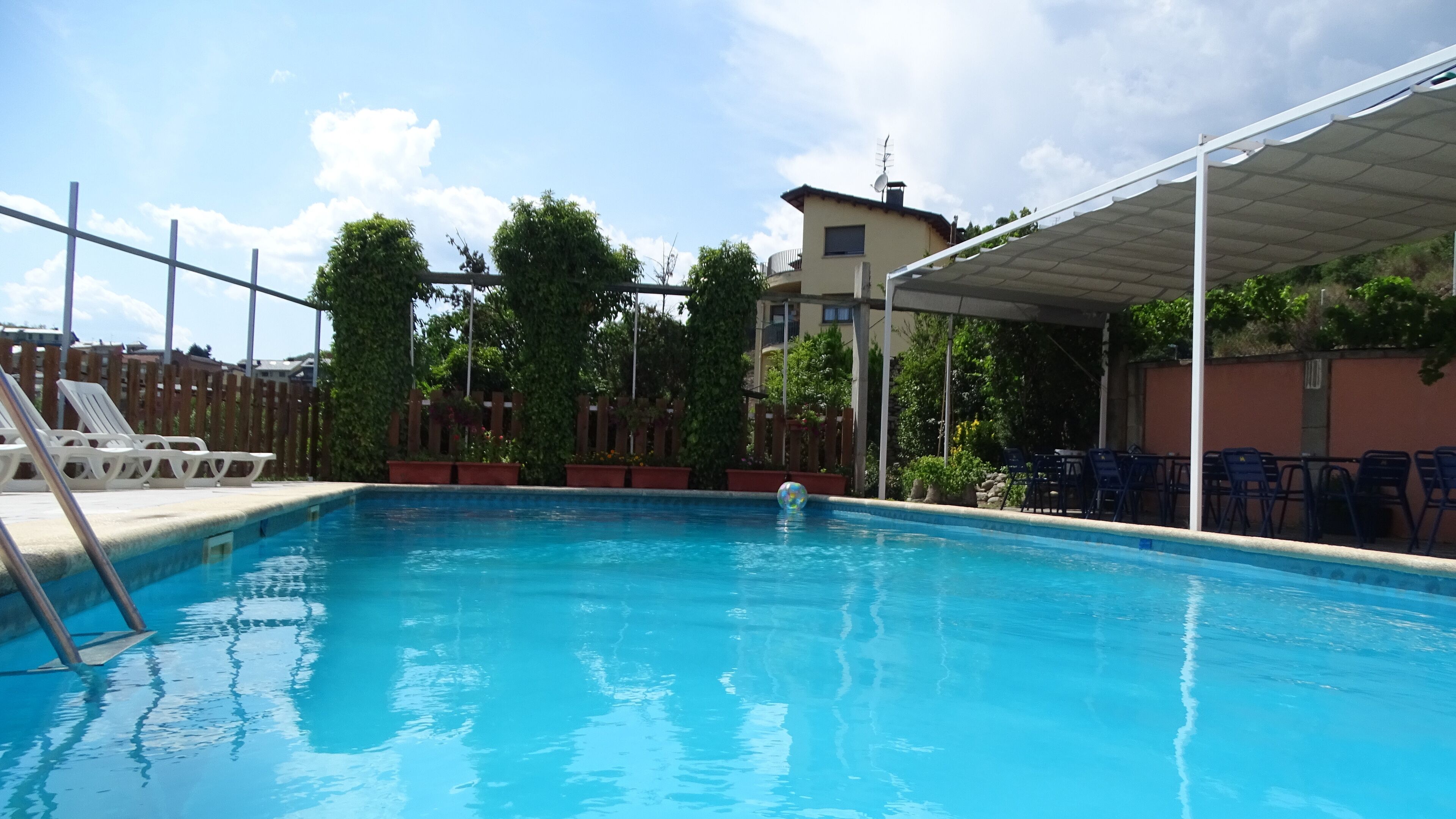 Una piscina con un pontile in legno e sedie a sdraio.