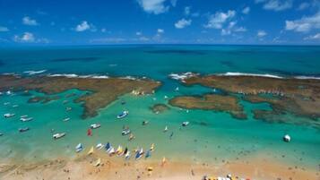Enjoy a day of swimming and sunbathing on the beach, where boats bob gently in the calm waters.