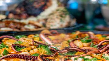 Un bufé con diversos platos, entre ellos mariscos y verduras.