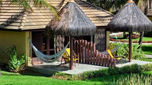 A resort with thatched-roof structures, a hammock, and a pool area.