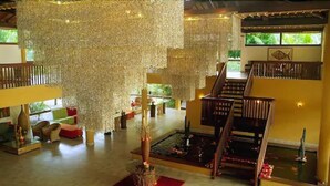 A spacious lobby with a central water feature, a staircase, and a seating area with cushions.