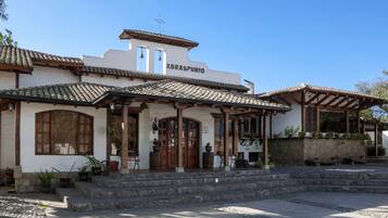 A traditional building with a tiled roof, a sign reading "ABRASPUNO," and a stone staircase leading to the entrance.