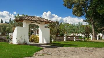 A white building with a tiled roof and the inscription "ABRAS POMED" on its entrance.