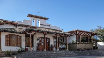 A building with a sign reading "ABRASPUNEO". It features a tiled roof, wooden beams, and a stone staircase leading to the entrance.