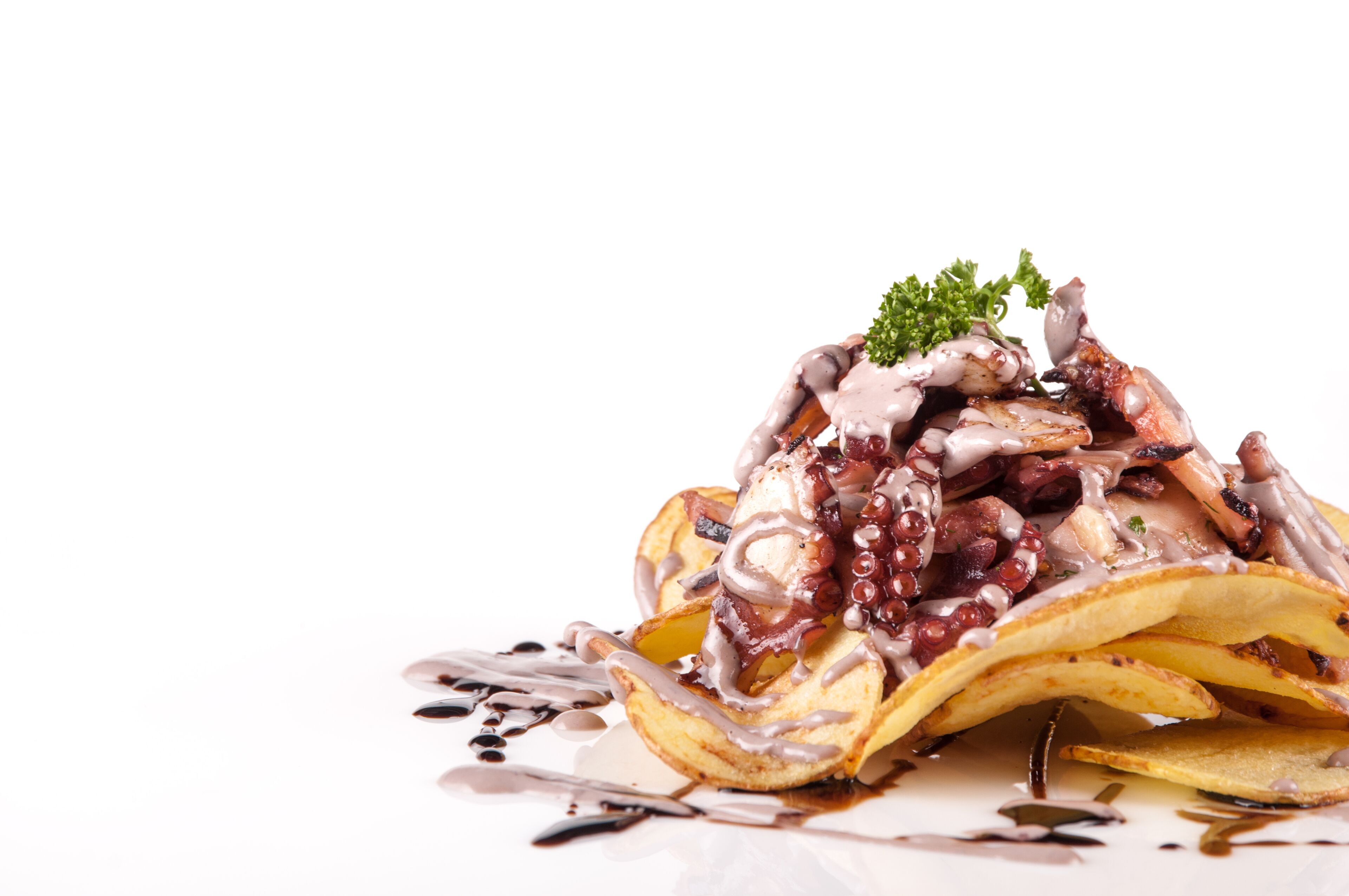 Una pila de panqueques cubiertos con diversos ingredientes y una guarnición.