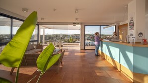 A modern kitchen with a large island, a dining area with a view, and a balcony with a view. -  Bimbolla Apartaments (Sant Lluis)
