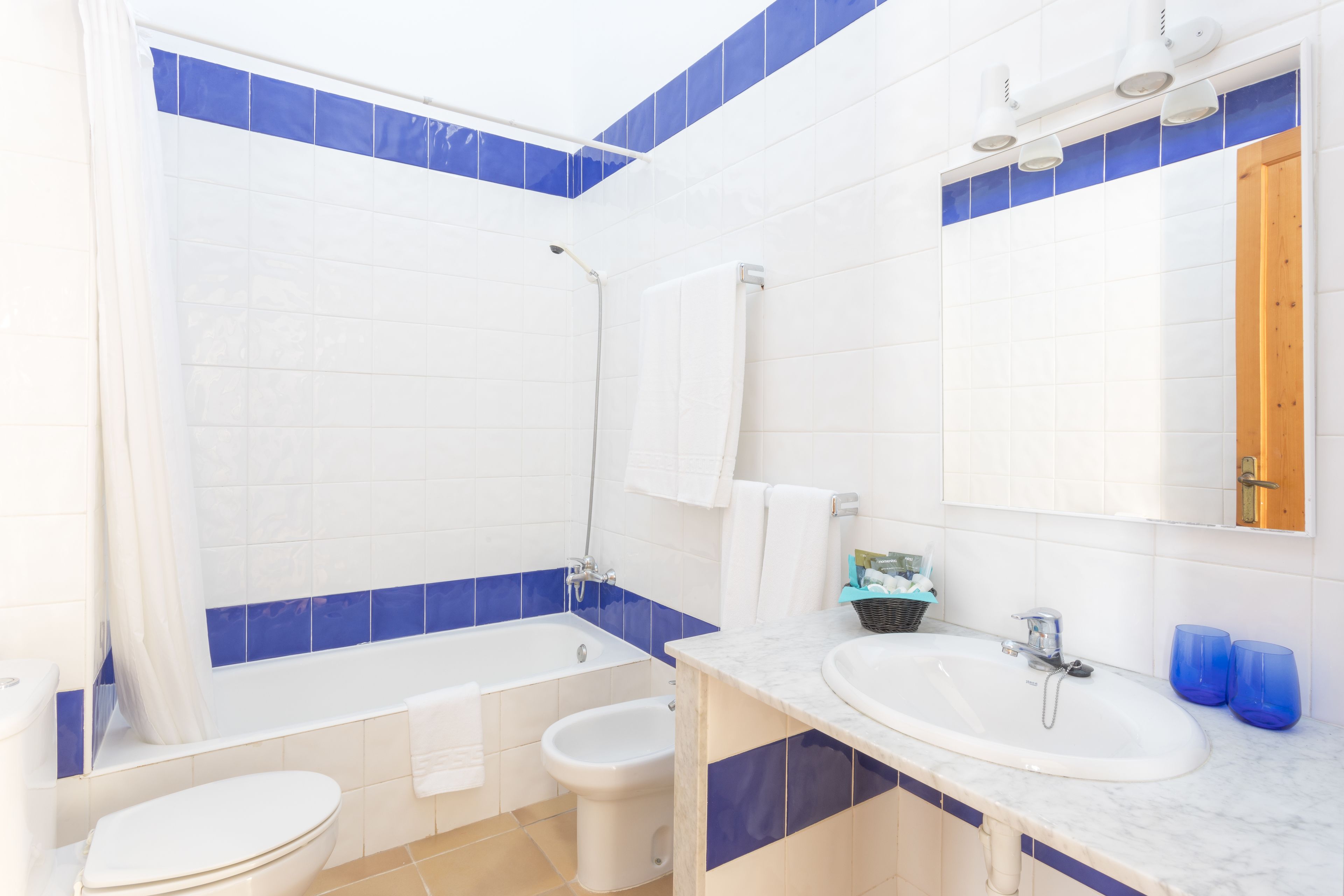 A bathroom with a bathtub, a sink, and a bidet.