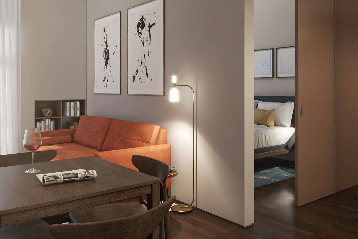A modern living room with a dining area, a sofa, a coffee table, and a floor lamp. There are two framed artworks on the wall.