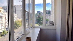 A room with a large window, a wooden bench, and a bowl on the windowsill. - Lukyanovsky (Kyiv)