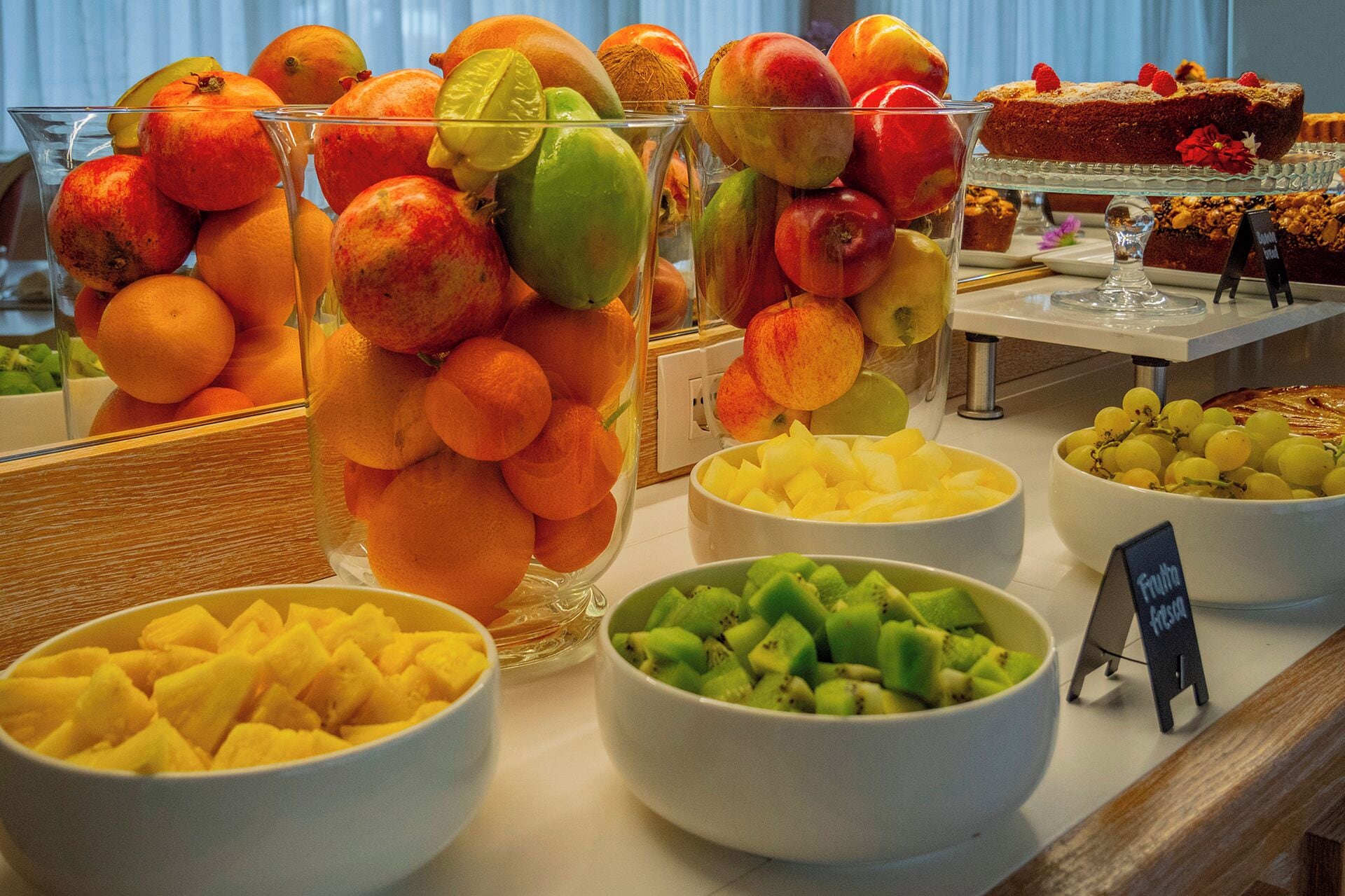 A buffet with various fruits and desserts.