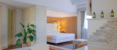 Habitación de hotel con cama, mesita de noche, planta, baño con bañera y chimenea de piedra.