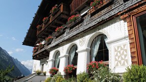 A traditional chalet with wooden balconies, arched windows, and flower boxes. - Landhaus Edelweiss (Sankt Leonhard im Pitztal)