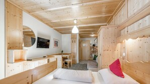 A wooden cabin room with two beds, a desk, and a mirror. - Landhaus Edelweiss (Sankt Leonhard im Pitztal)