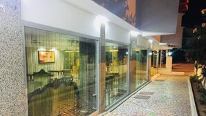 Un edificio moderno con grandes ventanales y un camino empedrado.