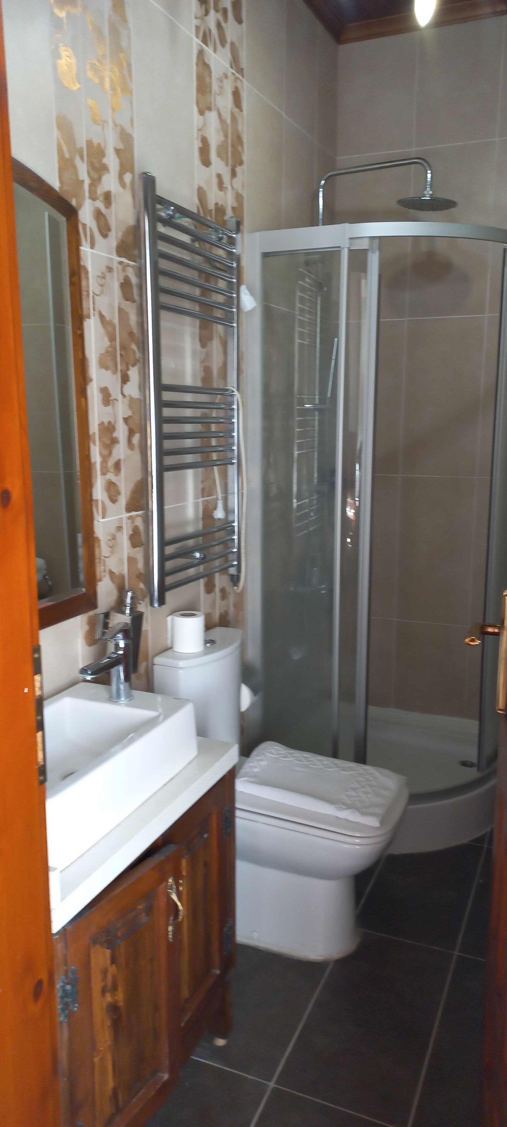 A bathroom with a shower, sink, toilet, and a mirror.