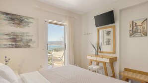 Une chambre à coucher avec un lit, un bureau, une chaise, une télévision et un tableau.