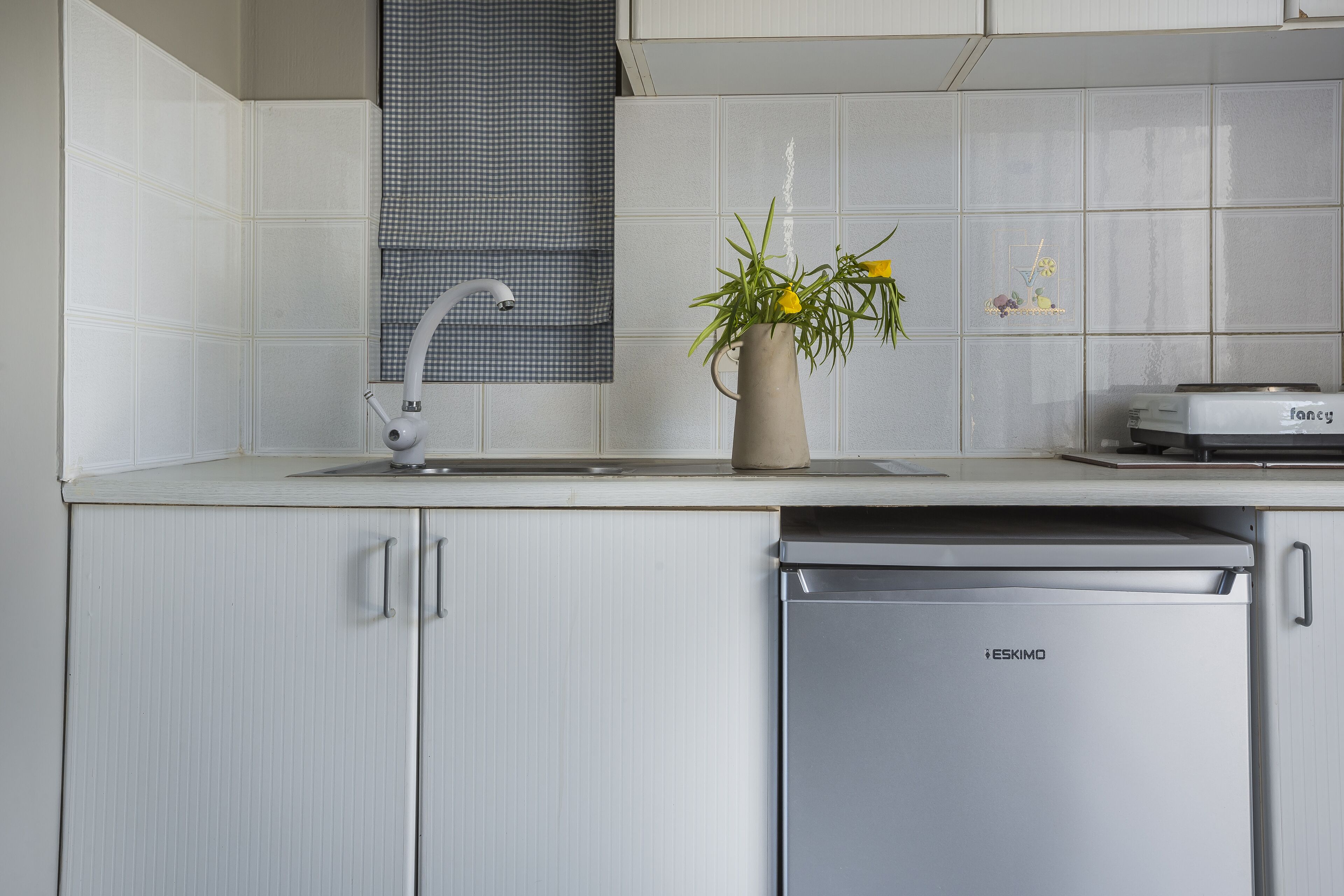 A kitchen with white cabinets, a dishwasher, and a sink with a faucet.