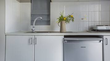 A kitchen with white cabinets, a dishwasher, and a sink with a faucet.